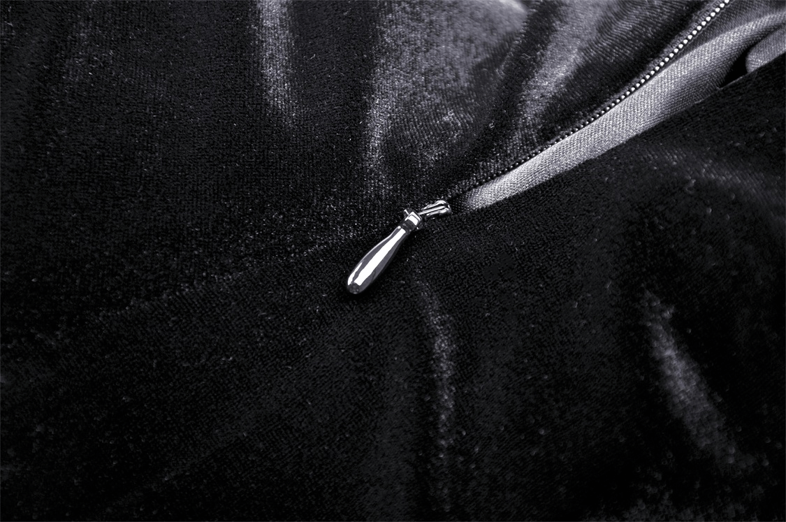 Close-up of a shiny zipper on luxurious black velvet fabric, showcasing detail and elegance.