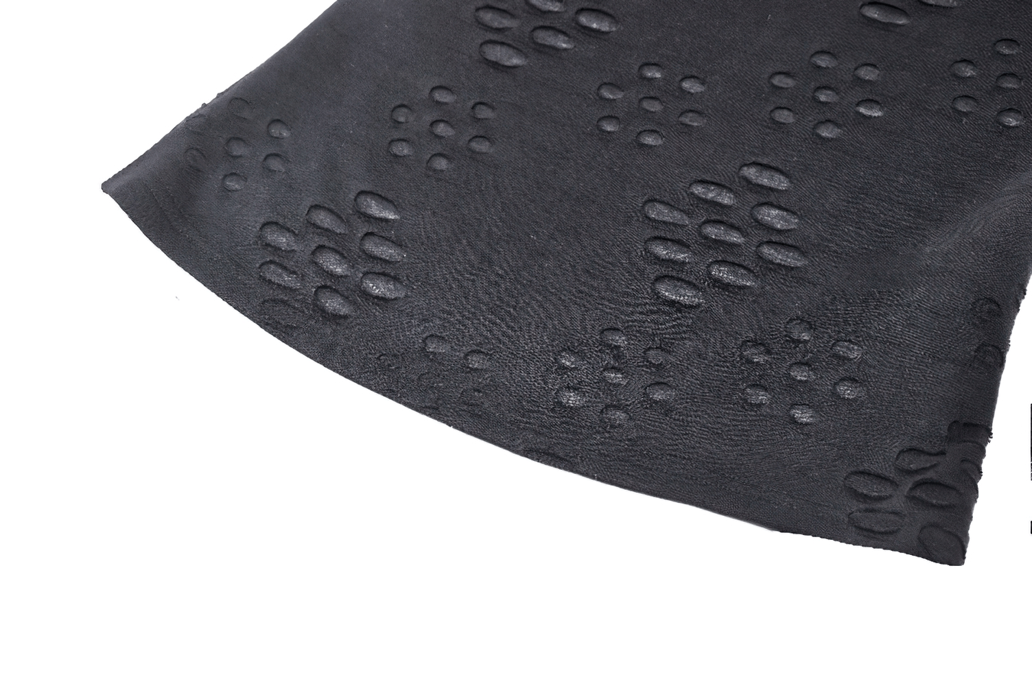 Close-up of black top fabric featuring unique cut-out texture, ideal for a punk-rock style outfit with edgy flair.