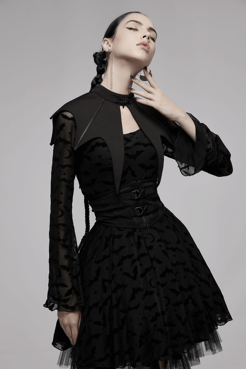 Elegant model in dark gothic bat cape and dress, showcasing edgy gothic fashion style.