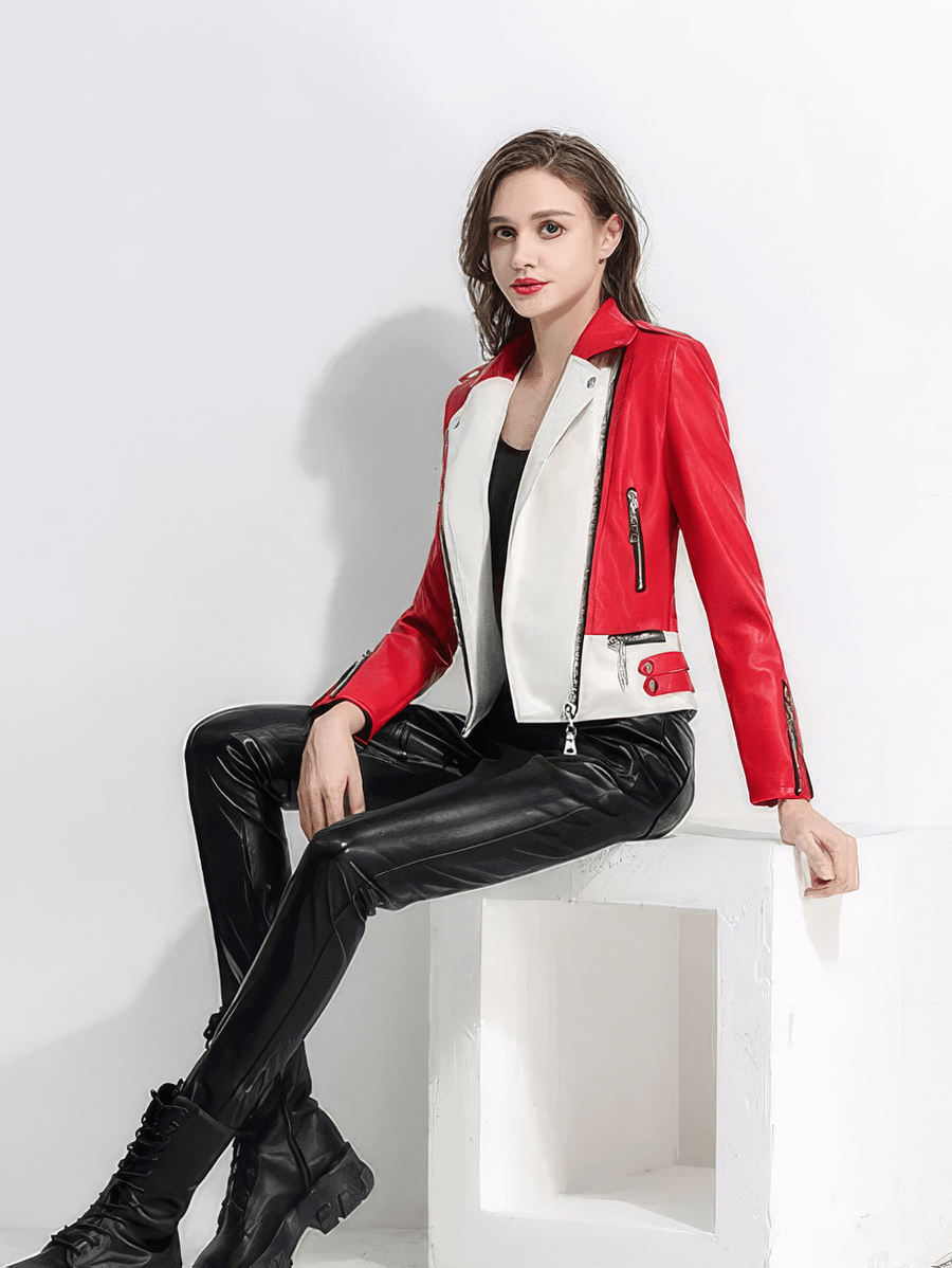 Stylish woman in red and white faux leather biker jacket, seated on a white pedestal, showcasing rock-inspired fashion.