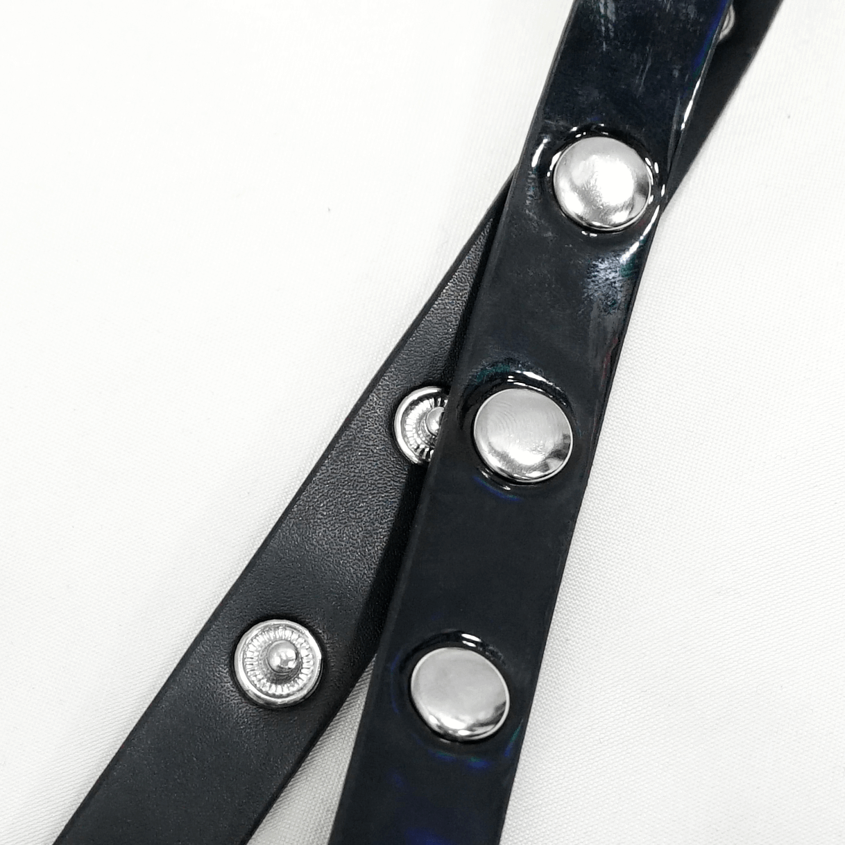 Close-up of women's gothic faux leather harness showing silver studs and adjustable straps, perfect for cosplay and fashion.