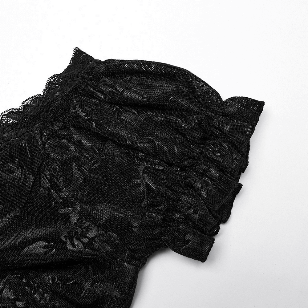 Close-up of black velvet fabric with rose pattern and lace trim, showcasing gothic dress detail.