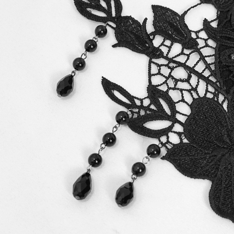 Close-up of black floral lace with beaded accents, showcasing gothic elegance and intricate detailing.