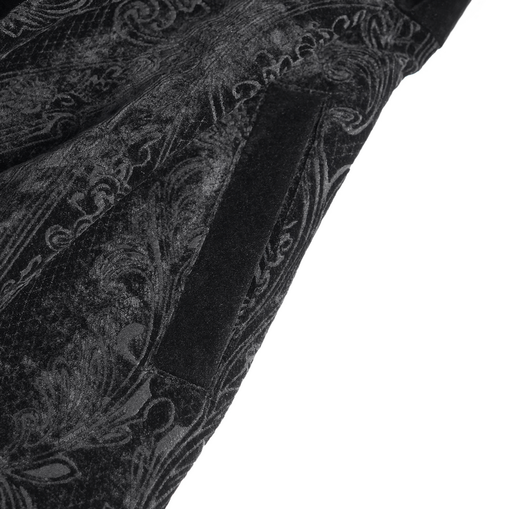 Close-up of intricate paisley pattern on a luxurious black coat with lace-up waist details.