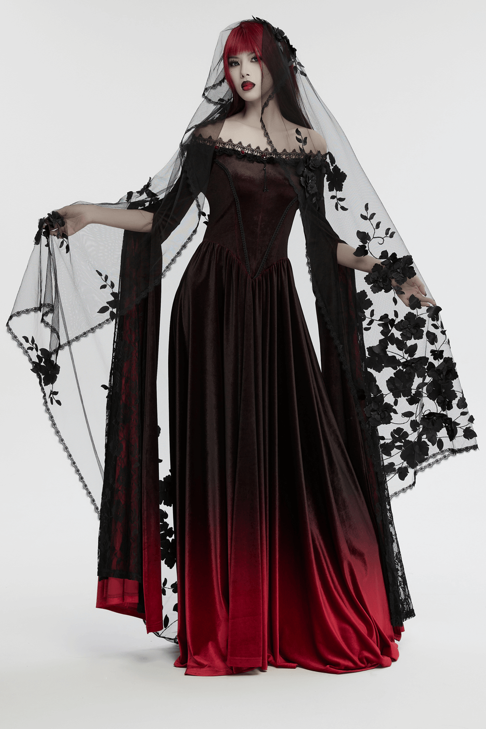 Gothic woman in black and red gown wearing a floral lace veil, exuding dark elegance and dramatic style.
