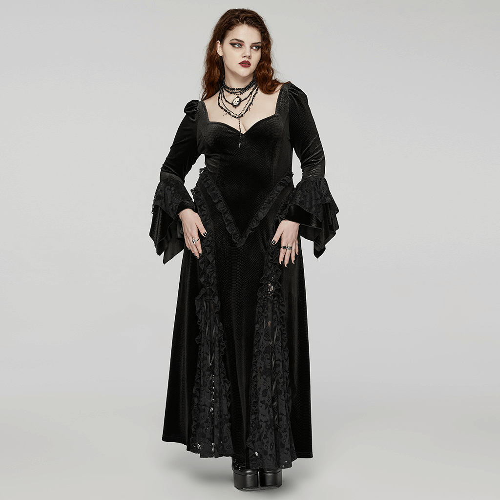 Elegant woman in a black Gothic dress with flowing sleeves, showcasing a dramatic, darkly stylish look.