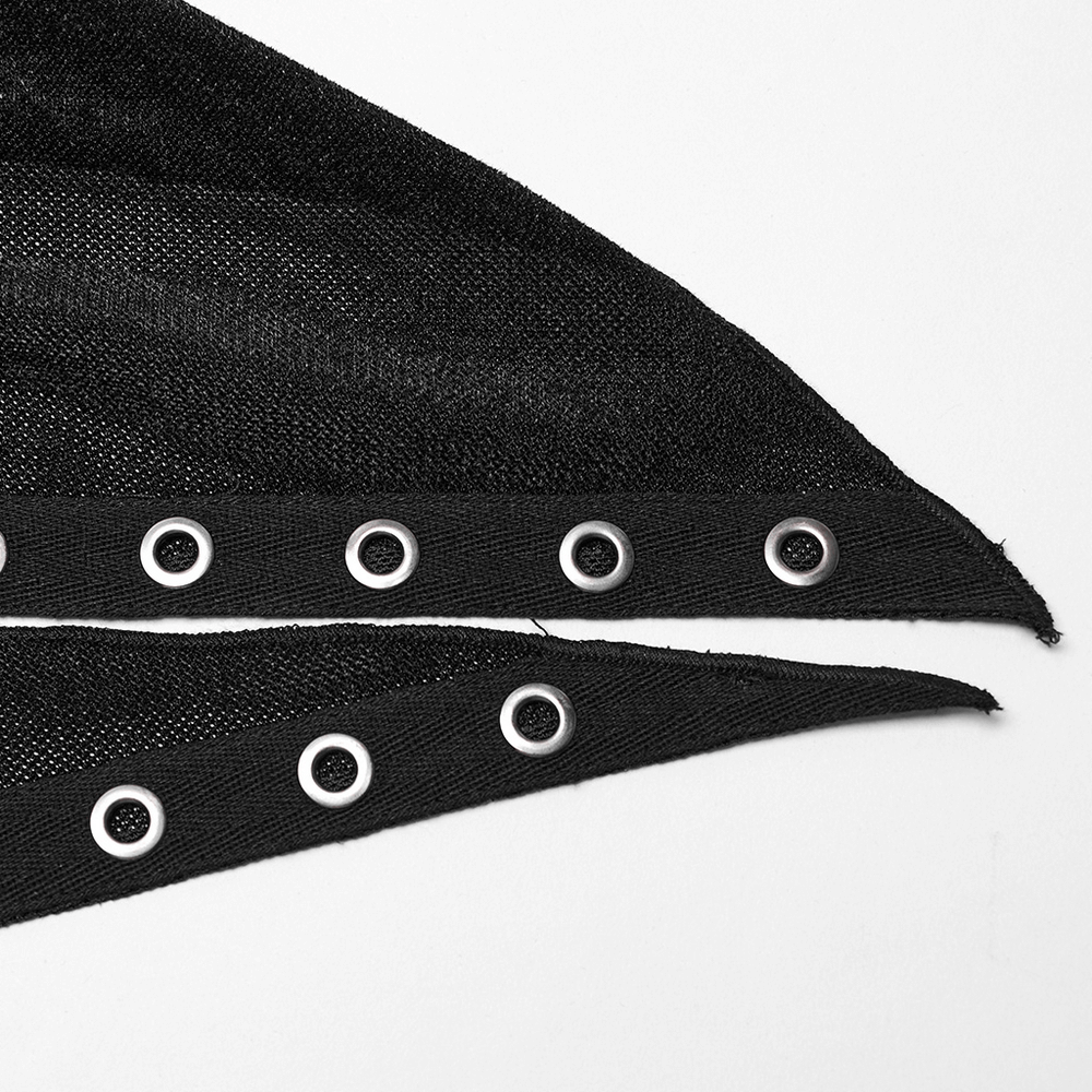 Close-up of black fabric with eyelet embellishments, showcasing the intricate detail of a Gothic hooded cape.