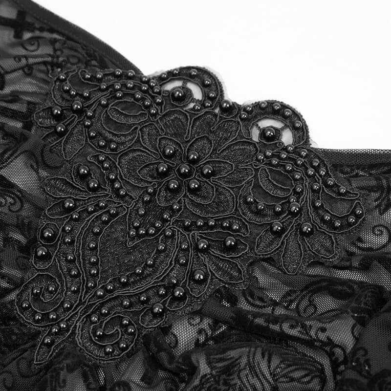 Close-up of intricate black floral embroidery and bead detailing on gothic lace fabric top.
