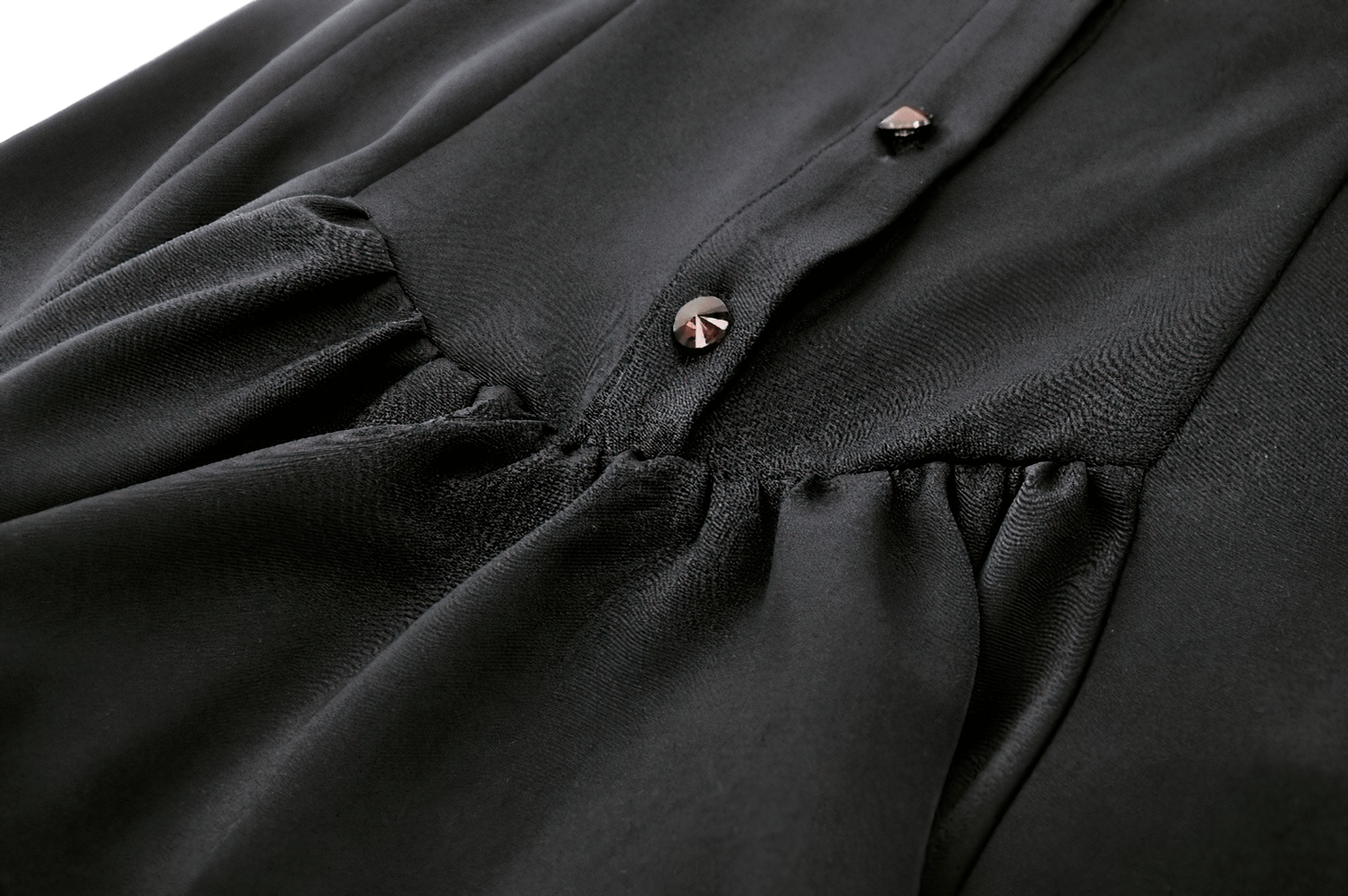 Close-up of a black gothic dress showing ruffled fabric and buttons, perfect for a bold style statement.