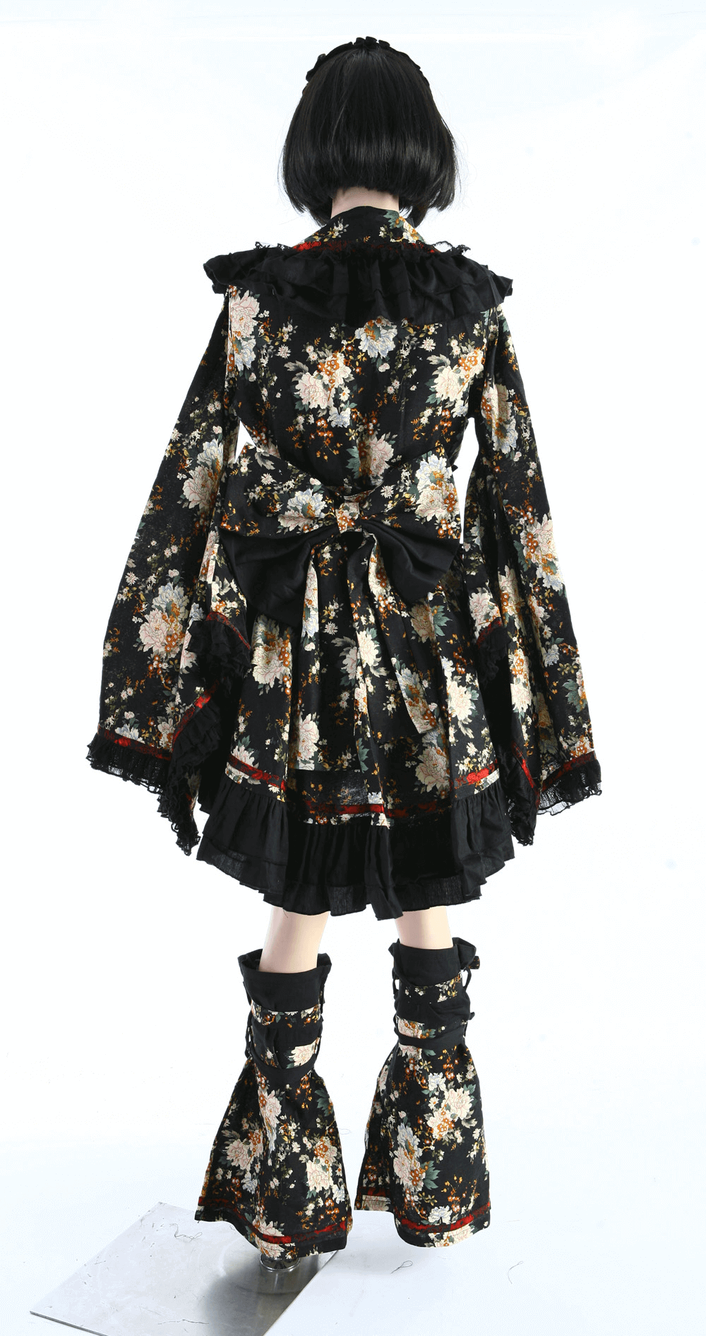Back view of a women's gothic black floral Lolita dress featuring ruffles, lace, and stylish accessories.