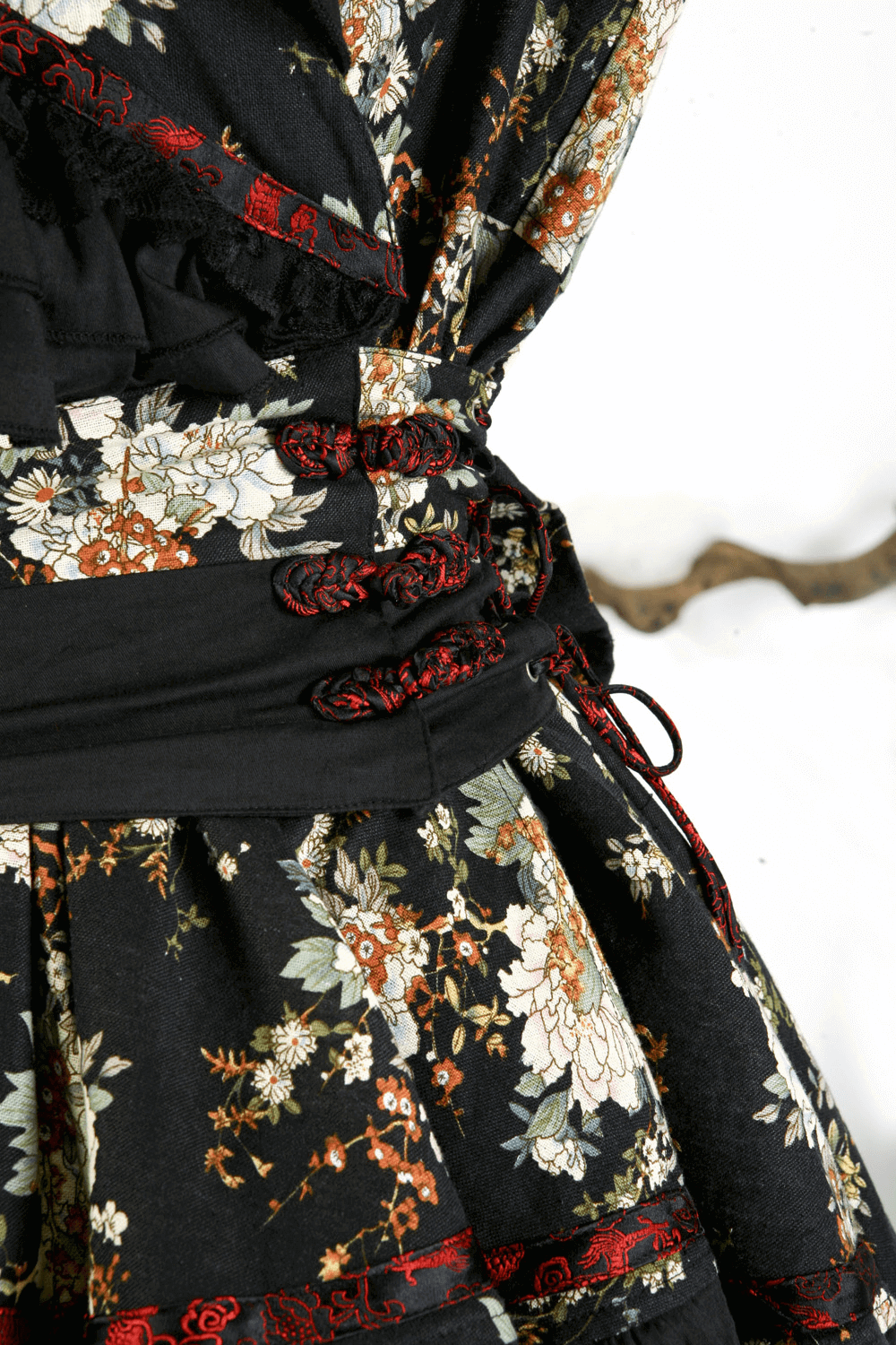 Close-up of a black floral gothic lolita dress showcasing intricate lace and ribbon details.