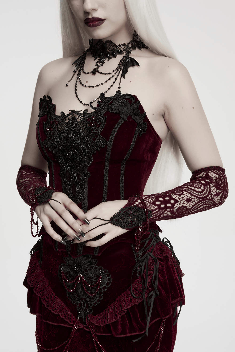 Women's Gothic Lace Arm Warmers With Crystal Details worn with an elegant burgundy outfit and intricate lace design.