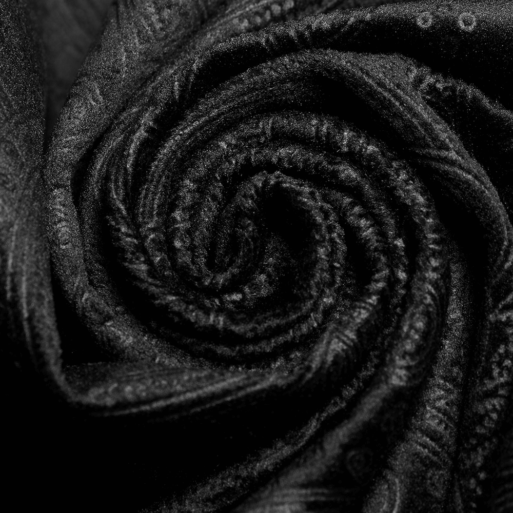 Close-up of luxurious Petzval-embossed black fabric, showcasing elegant swirl pattern texture for gothic fashion.