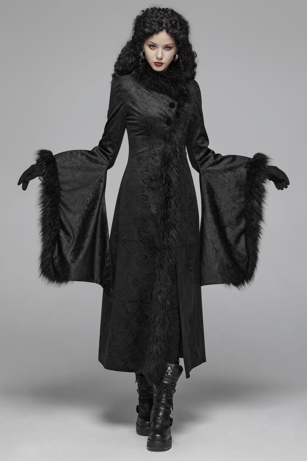 Elegant woman in a long black gothic coat with faux fur details and flared sleeves, showcasing gothic elegance.