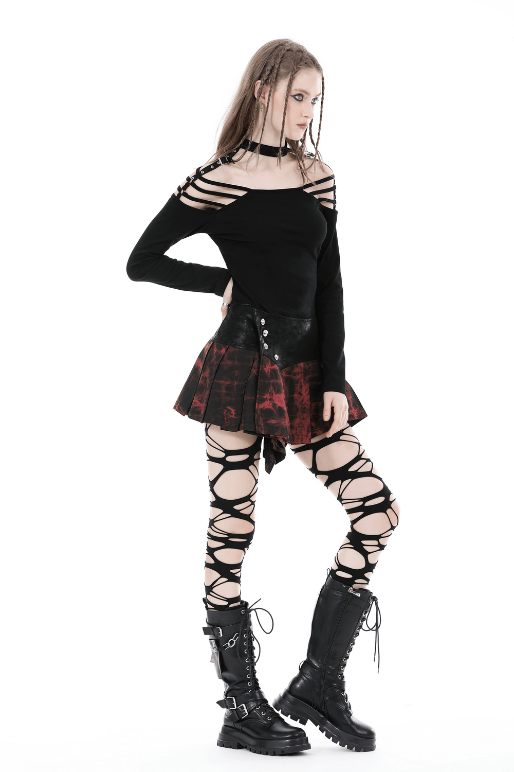 Edgy woman in Gothic mini skirt with button details and lace-up leggings, showcasing dark punk rock style.