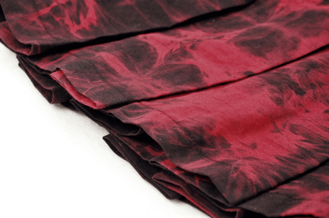 Close-up of a black and wine-red pleated mini skirt with marble print details, showcasing its edgy punk style.