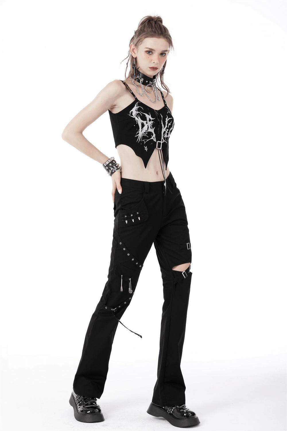 Stylish woman in black gothic punk crop top and edgy black pants with accessories, showcasing punk fashion.