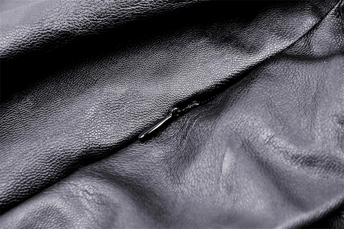 Close-up of the textured fabric on a women's gothic punk mini skirt, showcasing the sleek black material and zipper detail.