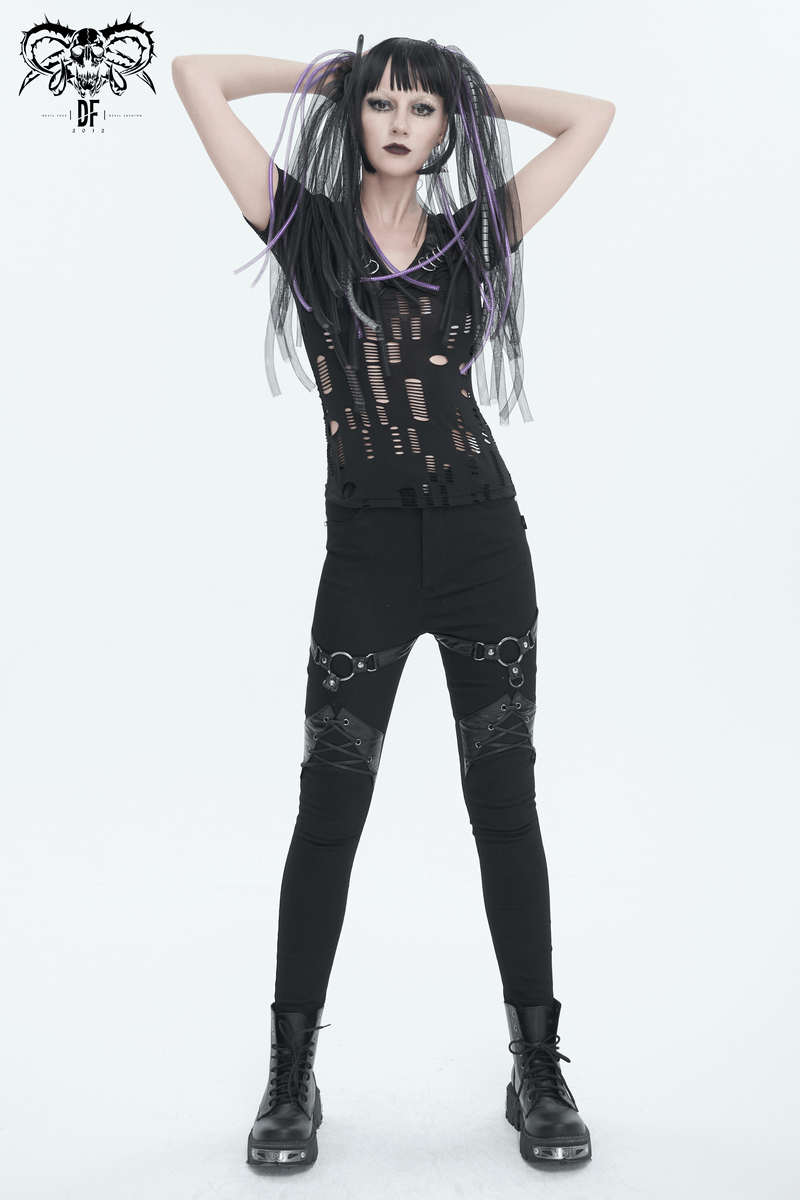 Confident model in black ripped mesh T-shirt and punk pants, showcasing gothic fashion with a bold, edgy style.