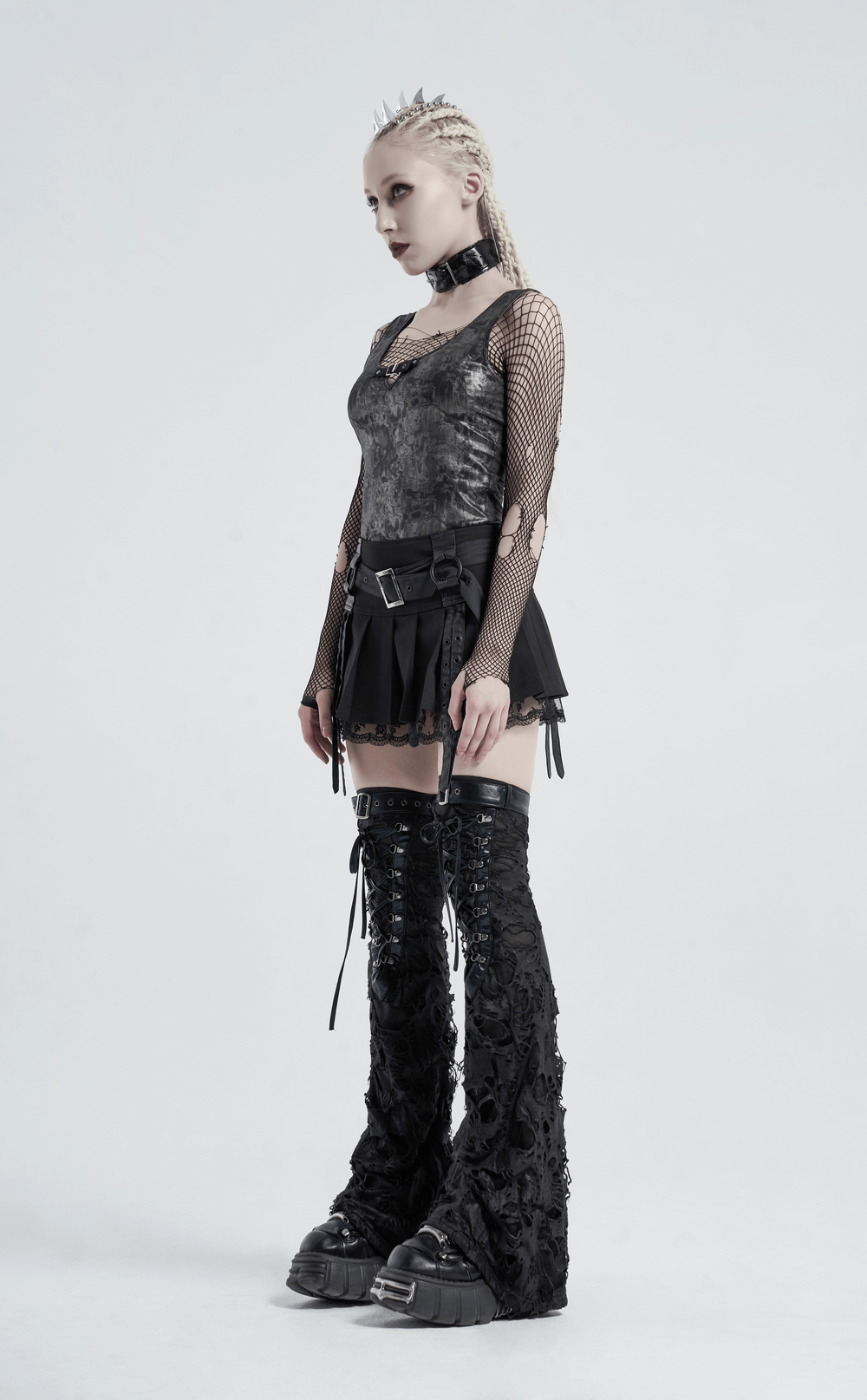 Stylish woman in gothic ripped strappy long leg warmers, showcasing a trendy punk look with black attire.