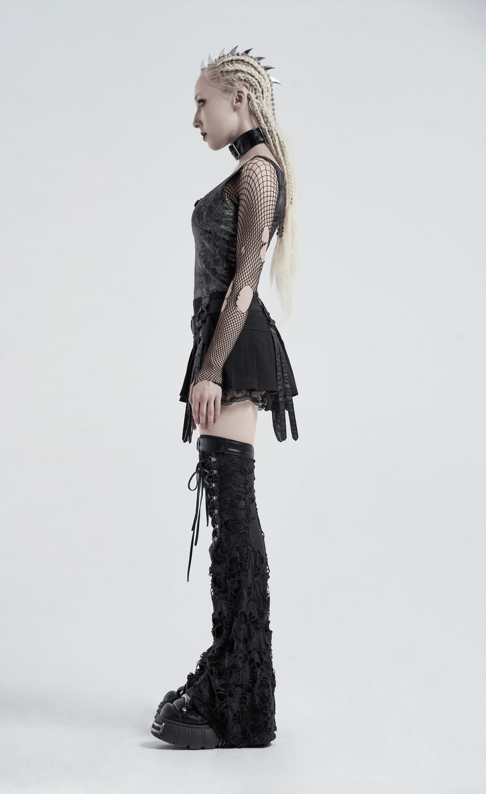 Woman in gothic attire wearing black ripped strappy long leg warmers, showcasing punk fashion style.