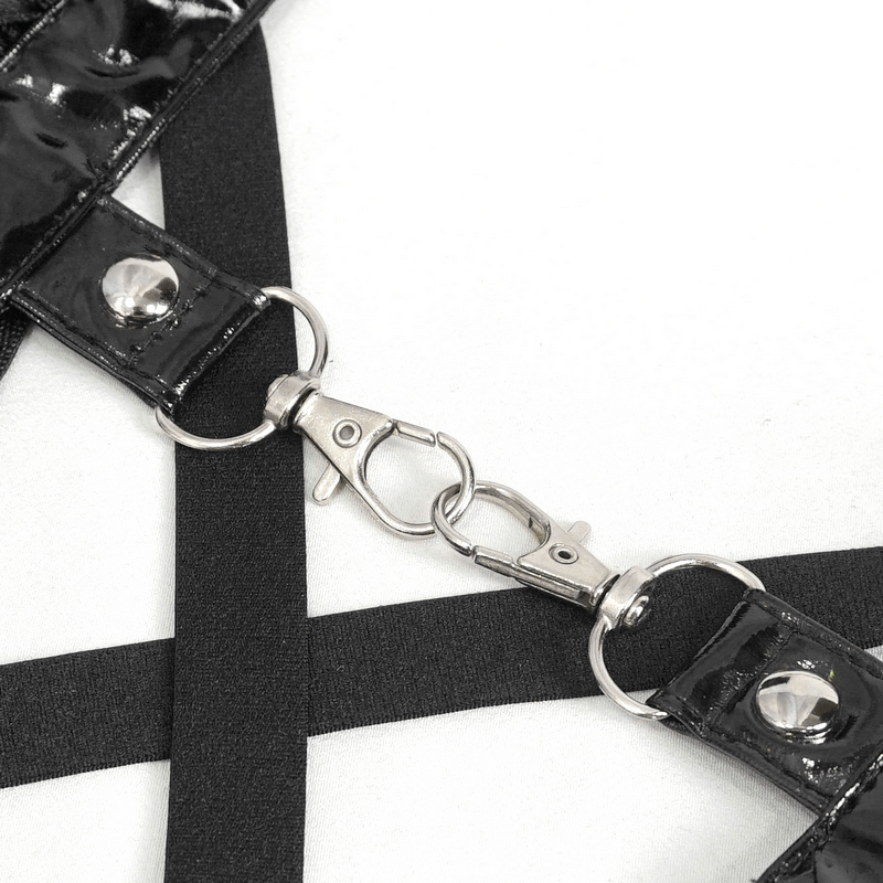 Close-up of black glossy straps with metal clasps on a harness, showcasing edgy style and intricate design details.