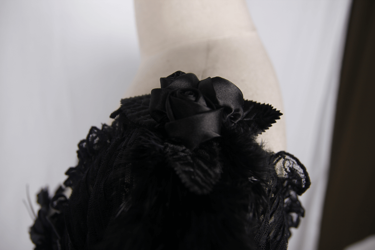 Close-up of black lace corset detailing with feathers and rose embellishments, perfect for gothic elegance.