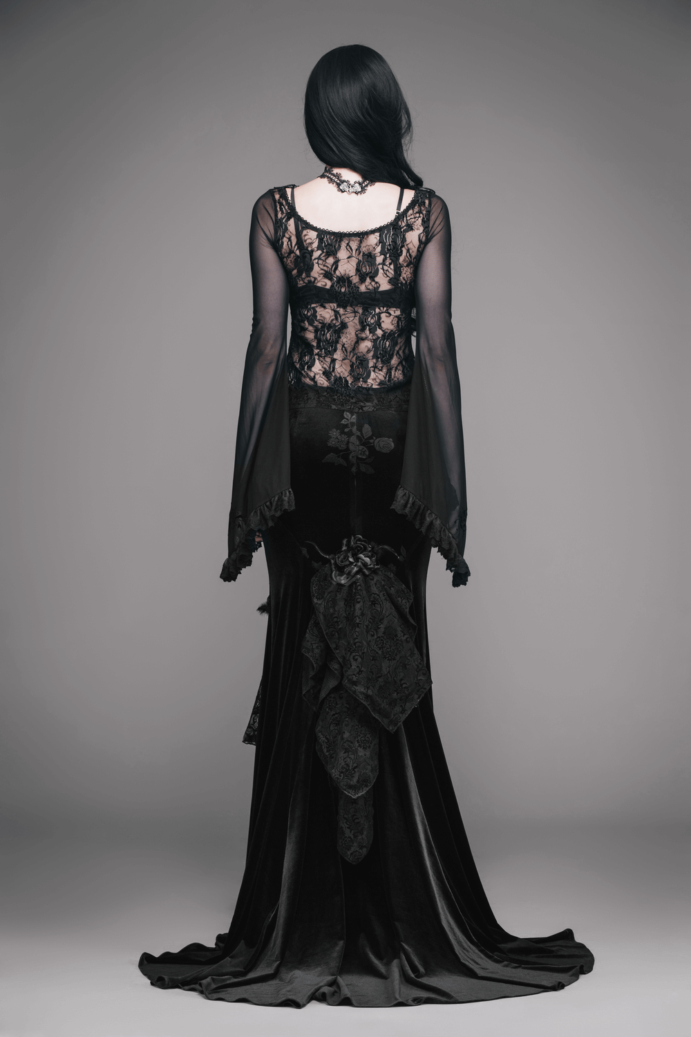 Elegant black gothic dress with lace details and flowing sleeves, showcasing a stunning silhouette from the back.