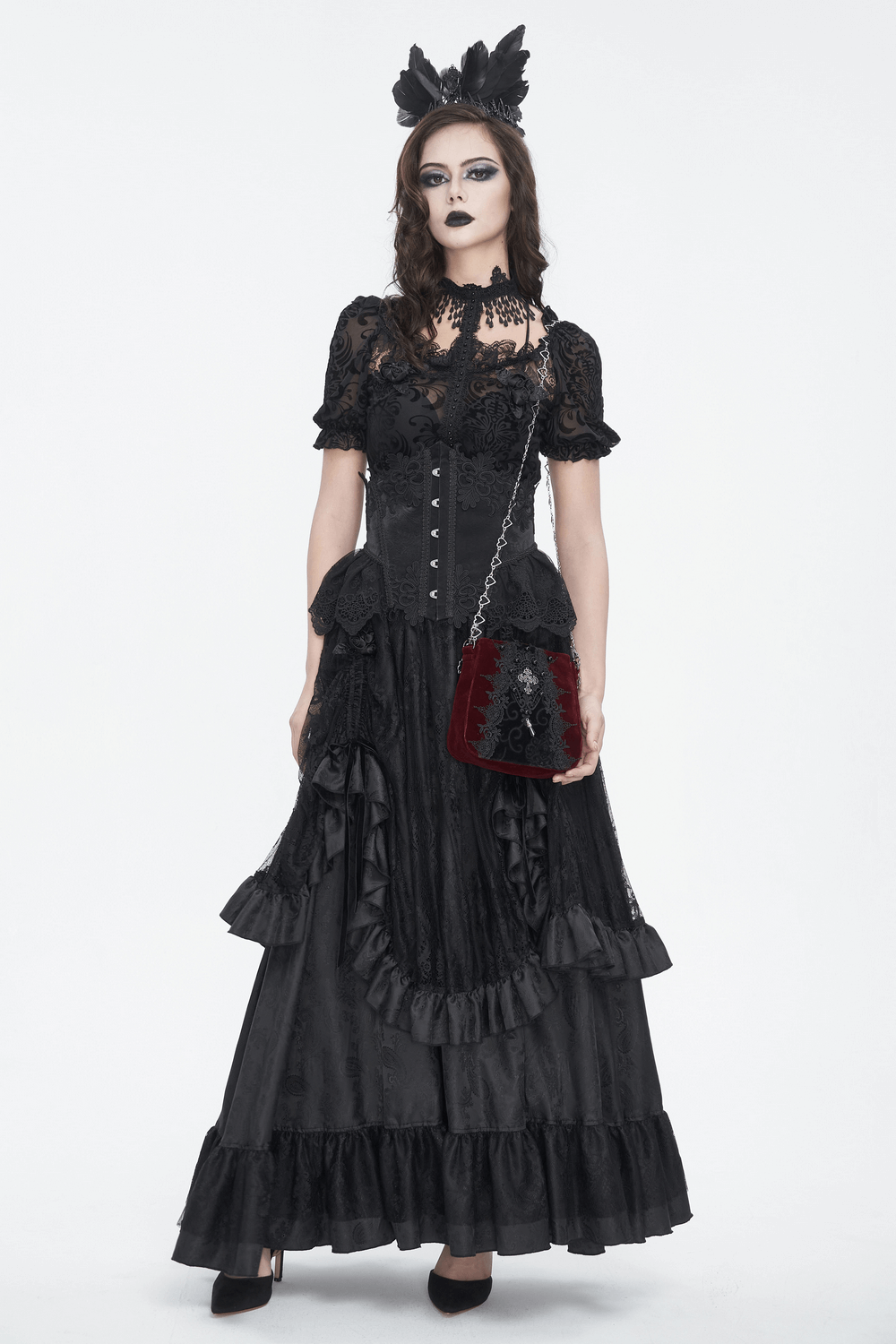 Woman in elegant gothic black dress with lace details and a velvet clutch bag, embodying Victorian style.