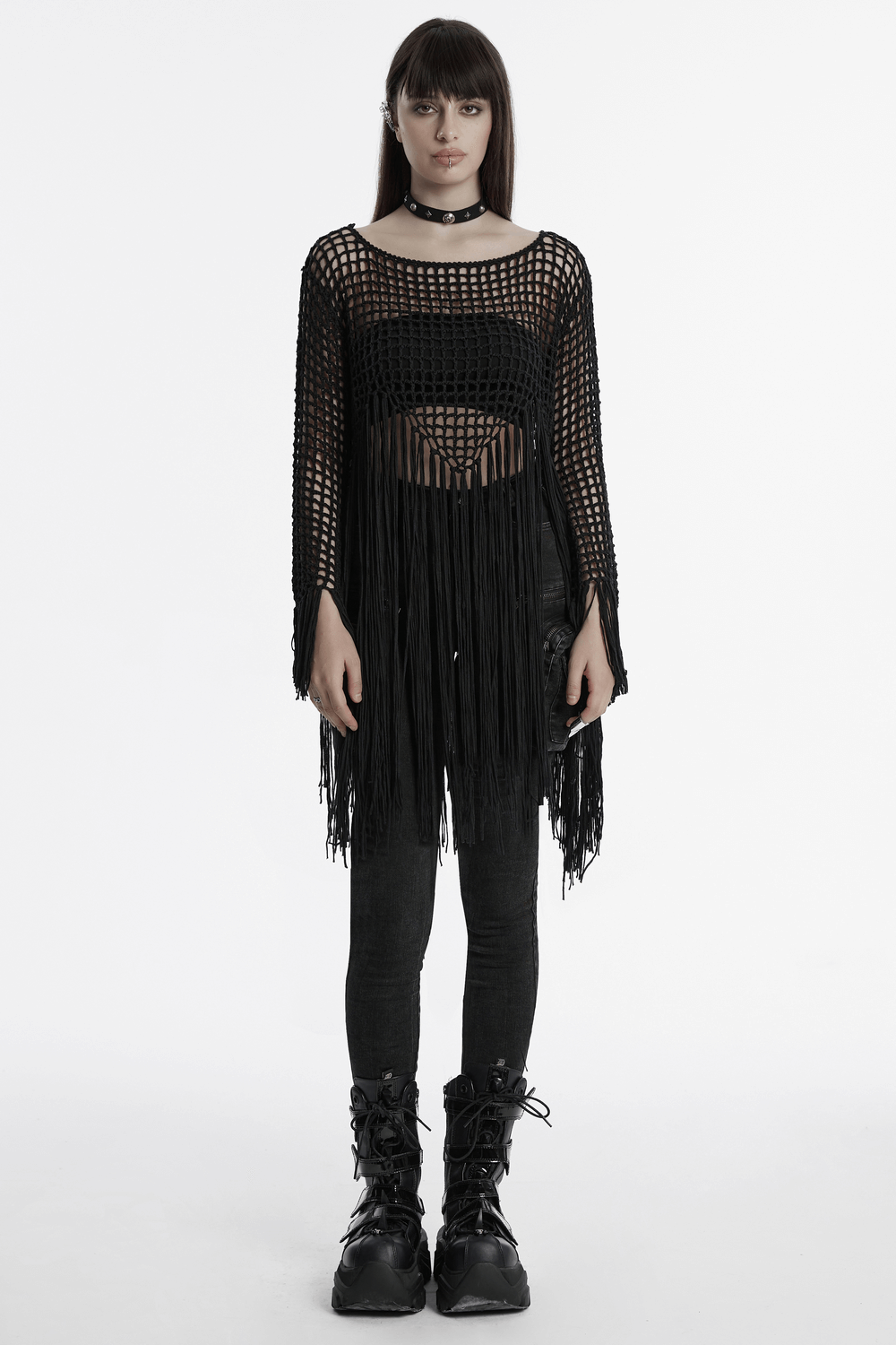 Edgy women's gothic tassel knit sweater with fringe, hollow design, paired with black leggings and chunky boots.