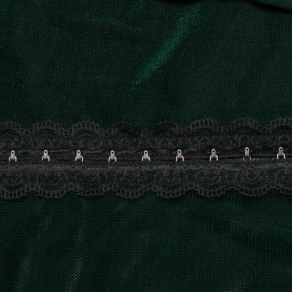 Close-up of green fabric with delicate black lace trim and hooks fastening, showcasing elegant detailing.