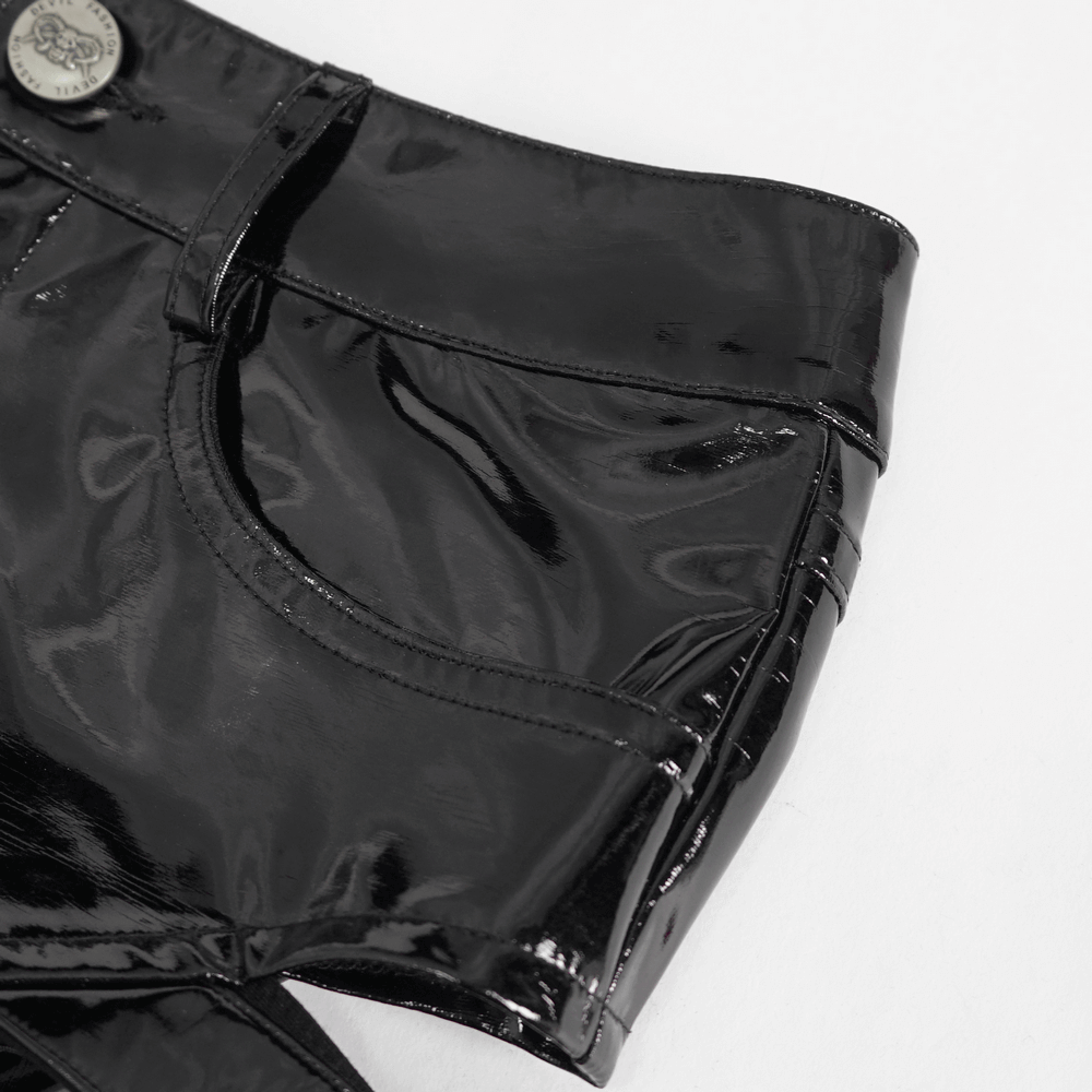 Close-up of high-waisted black faux leather shorts featuring shiny material and stylish buckle details.