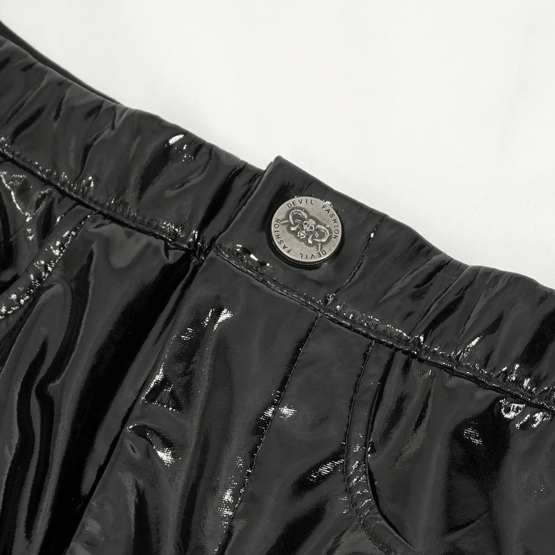 Close-up of the waistband and button on women's patent leather skinny pants with lace-up sides.