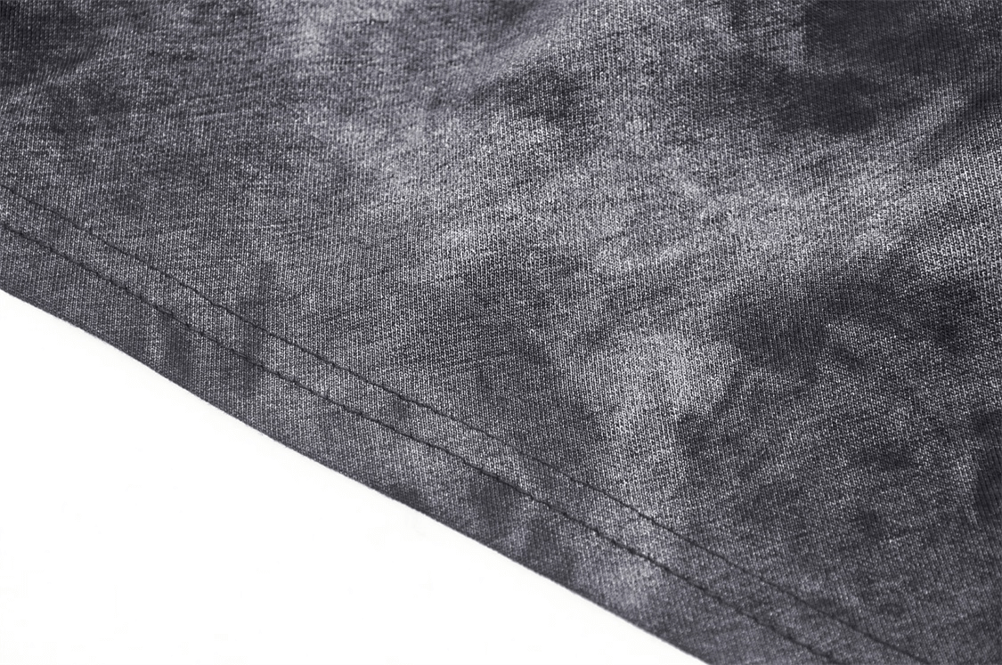 Close-up of the edgy fabric texture of a women's hooded sleeveless punk top with a dramatic design.