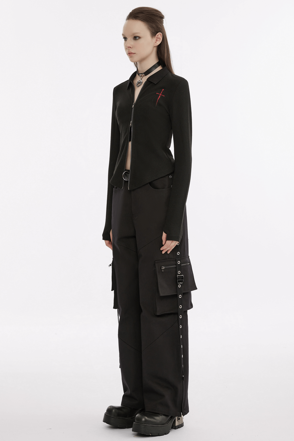 Women in a black knitted zippered top with red cross embroidery, paired with stylish cargo pants, showcasing a punk look.