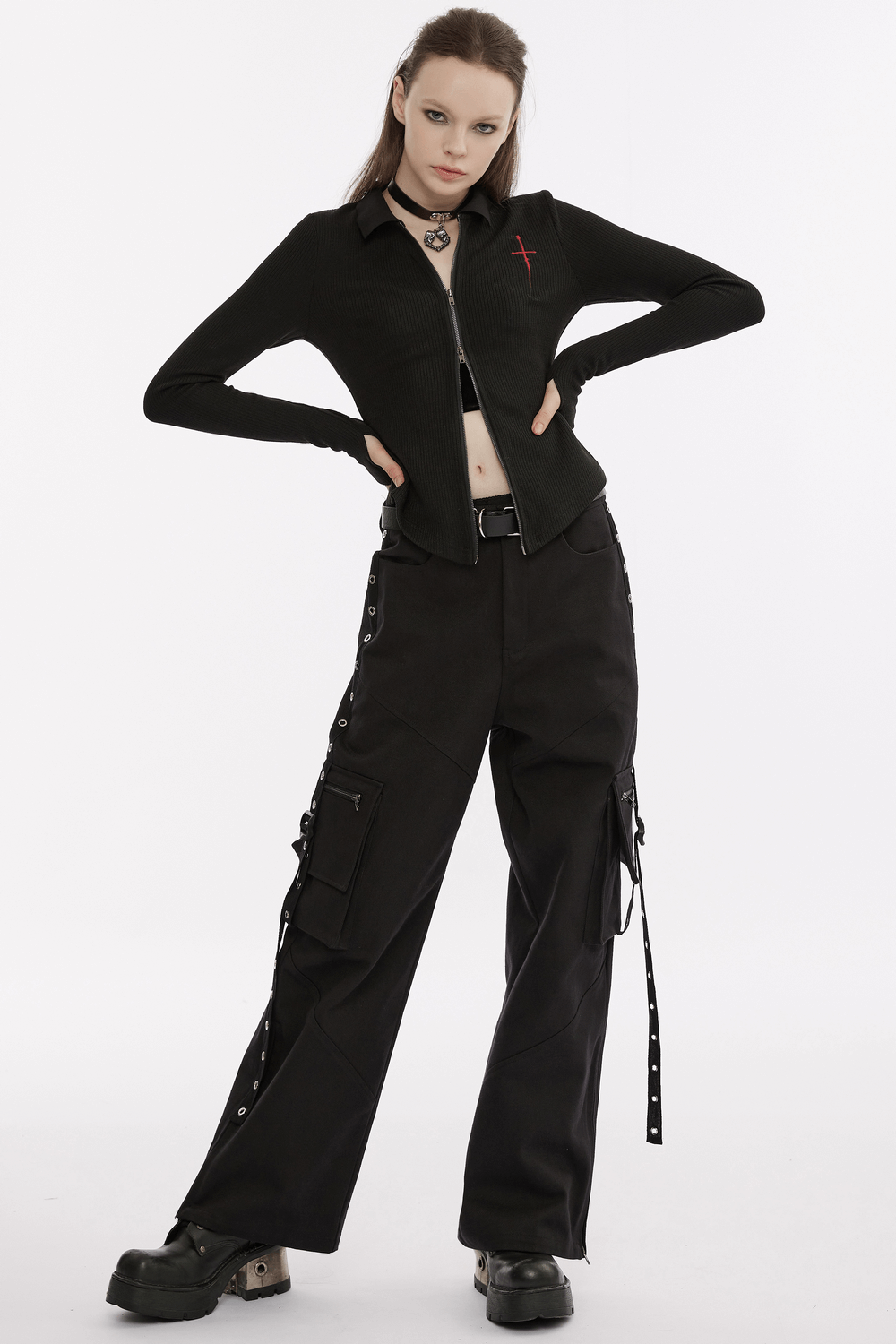 Women's black knitted zippered top with red cross embroidery, paired with edgy black cargo pants.