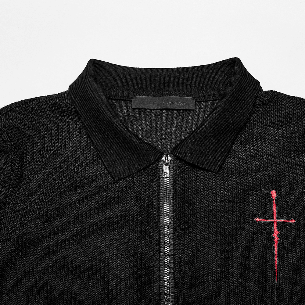 Close-up of a black knitted women's top featuring a red cross embroidery and zippered collar.