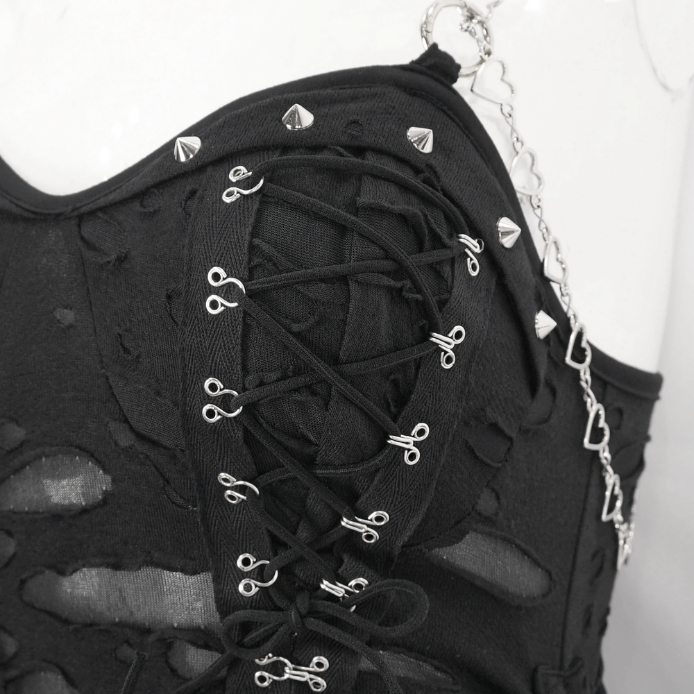 Close-up of black lace dress with edgy lace-up design and metal studs for a dramatic look.