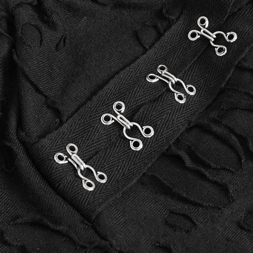 Close-up of silver chain detailing on a dramatic black lace dress with a unique design.