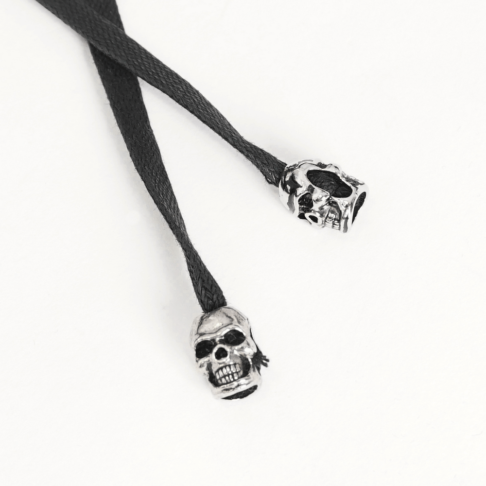 Black lace shoelaces with silver skull-shaped aglets for a edgy style.