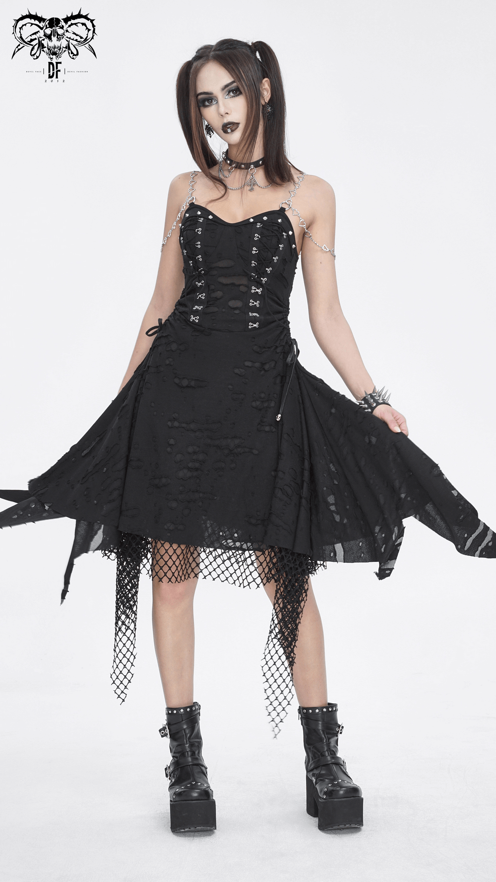 Edgy black lace dress with chains, asymmetrical hem, and fishnet details, perfect for a dramatic evening look.