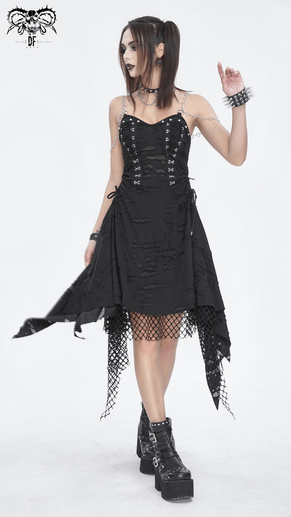 Edgy black lace dress with asymmetrical hem, chains, and punk accessories for a dramatic evening look.