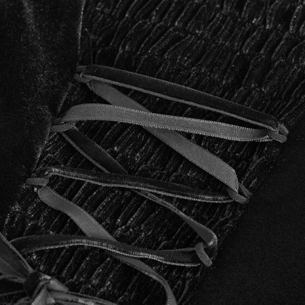 Close-up of black lace with ribbon detailing on a women's elegant evening dress.