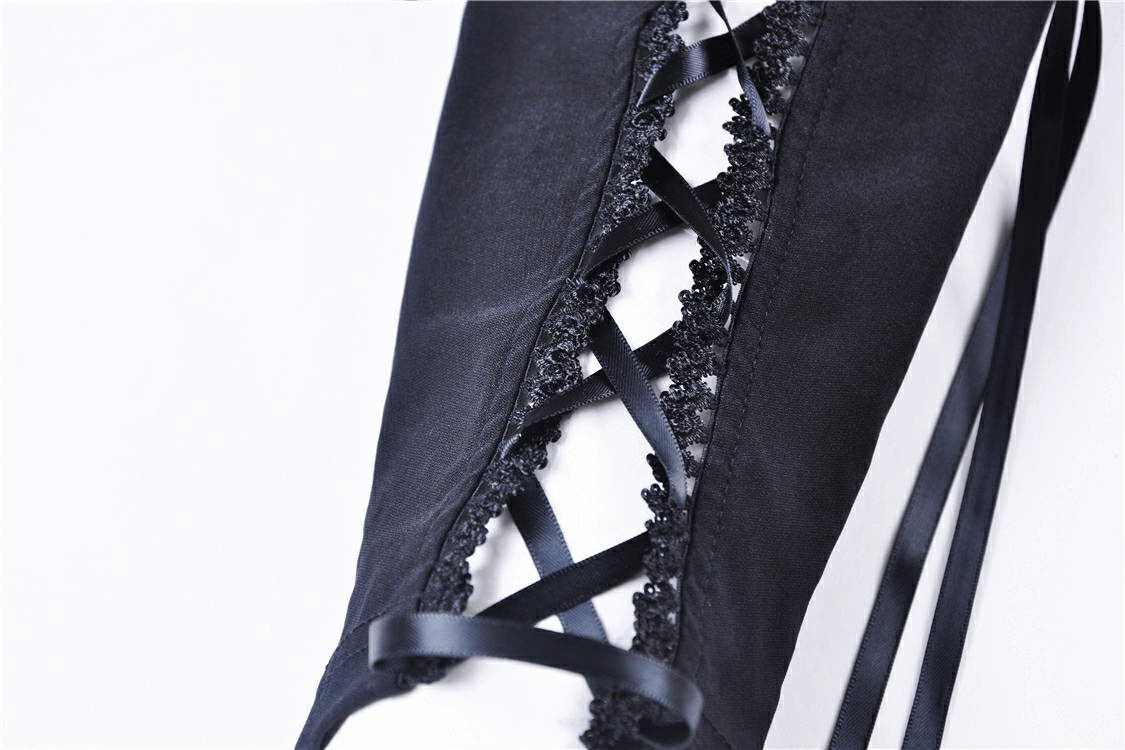 Close-up of black lace detailing and cross-lace design on women's leggings, showcasing elegant fashion elements.