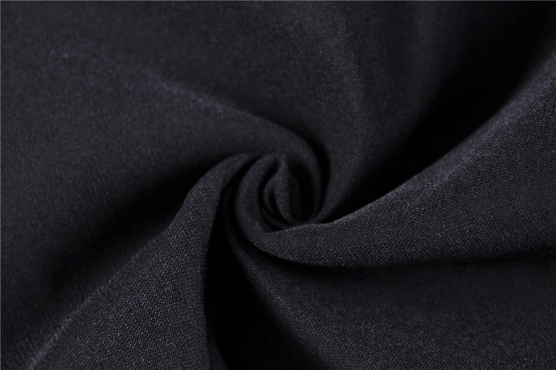 Close-up of soft black fabric showcasing the texture of stretch leggings with elegant lace detailing.