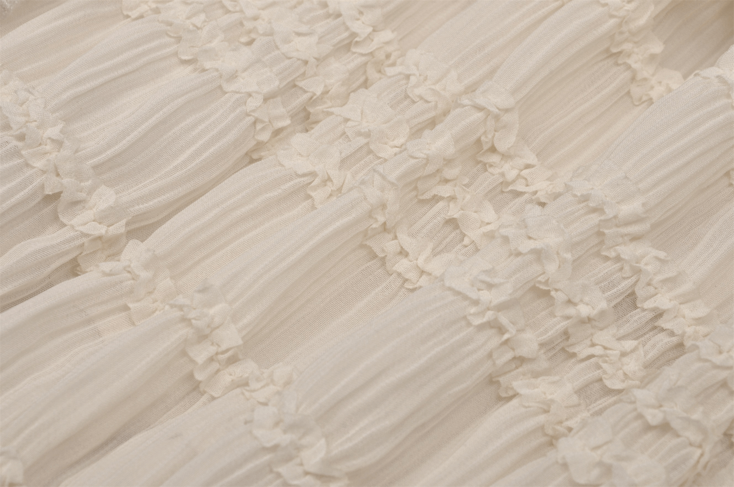 Close-up of ruffled cream lace fabric with delicate floral detailing, perfect for gothic mini dresses.