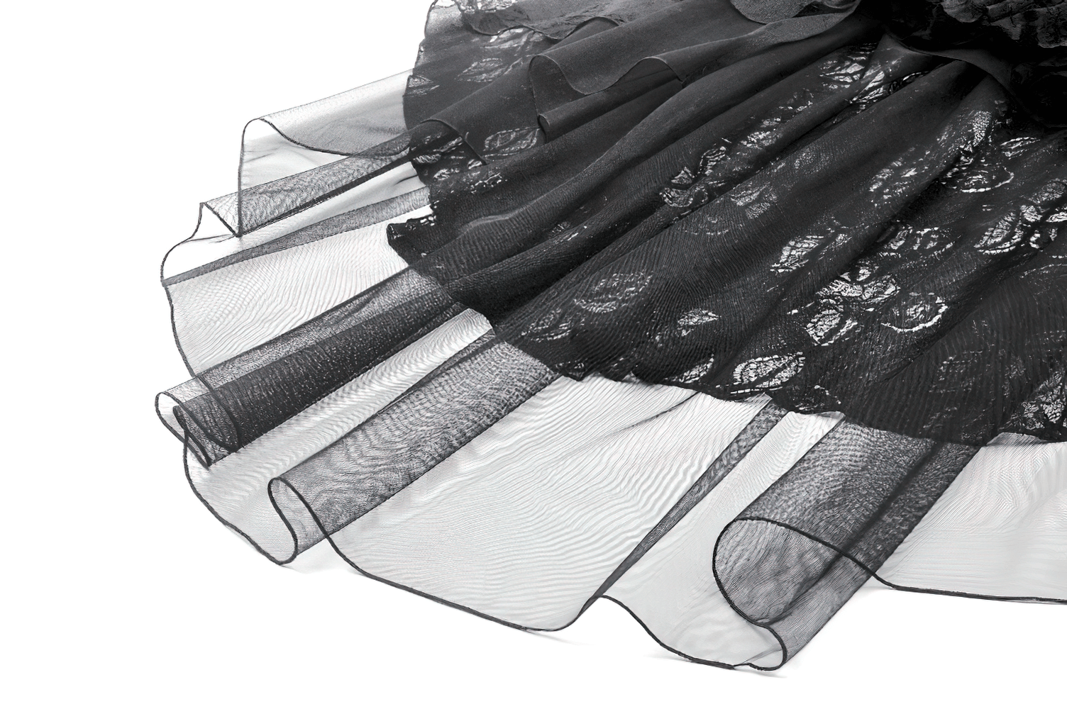 Close-up of a black lace ruffled high-low skirt with sheer tulle layers, showcasing intricate detailing and gothic elegance.