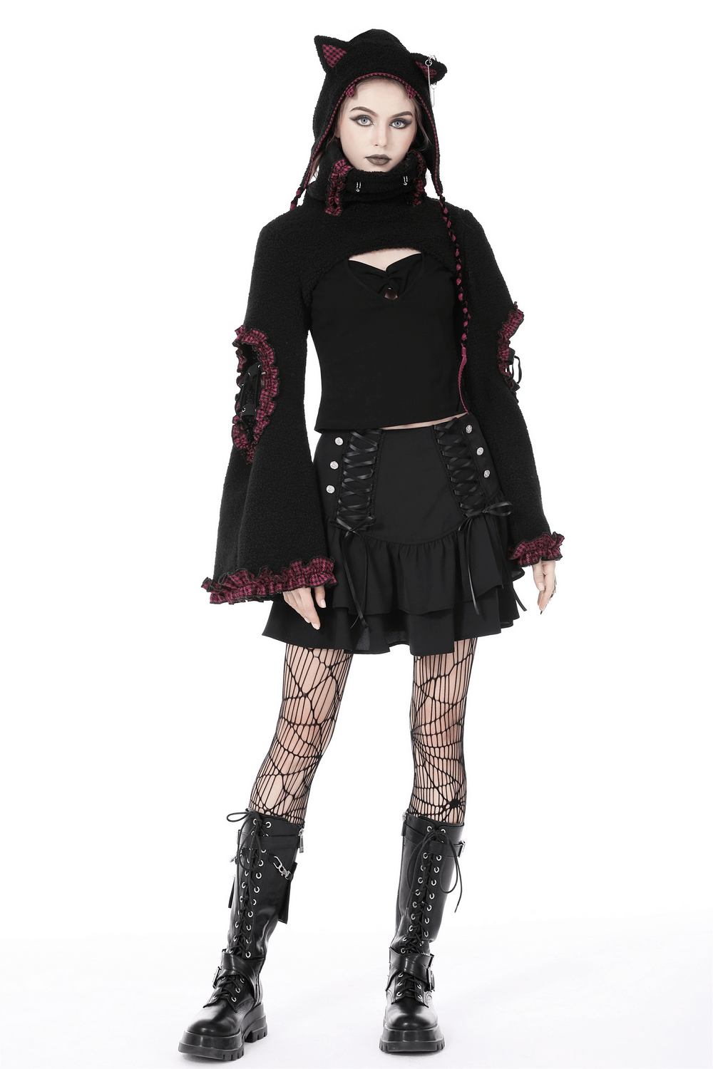 Gothic woman wearing a layered mini skirt with lace-up details, paired with a hooded top and fishnet stockings.