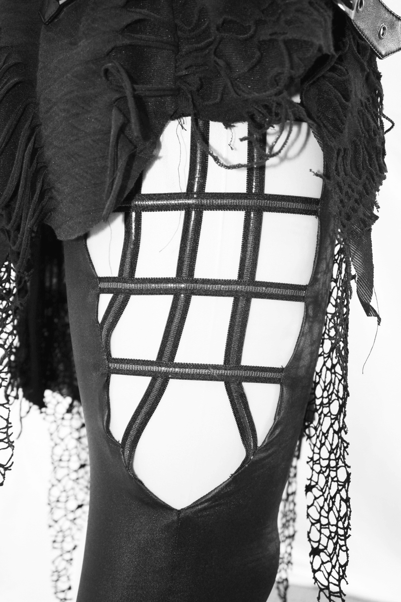 Close-up of women's black leggings featuring torn detail and layered asymmetrical skirt in gothic style fashion.