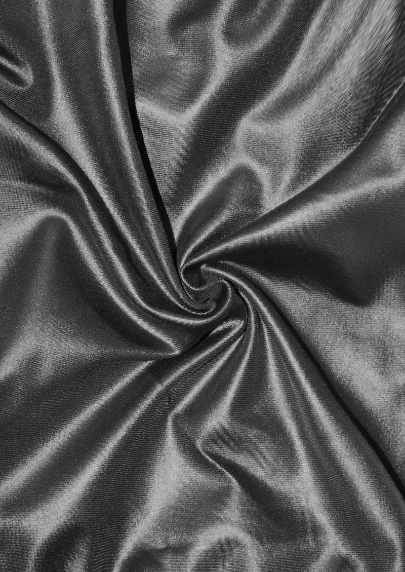 Close-up of luxurious black fabric with a smooth, shiny texture, ideal for gothic style clothing and trendy leggings.
